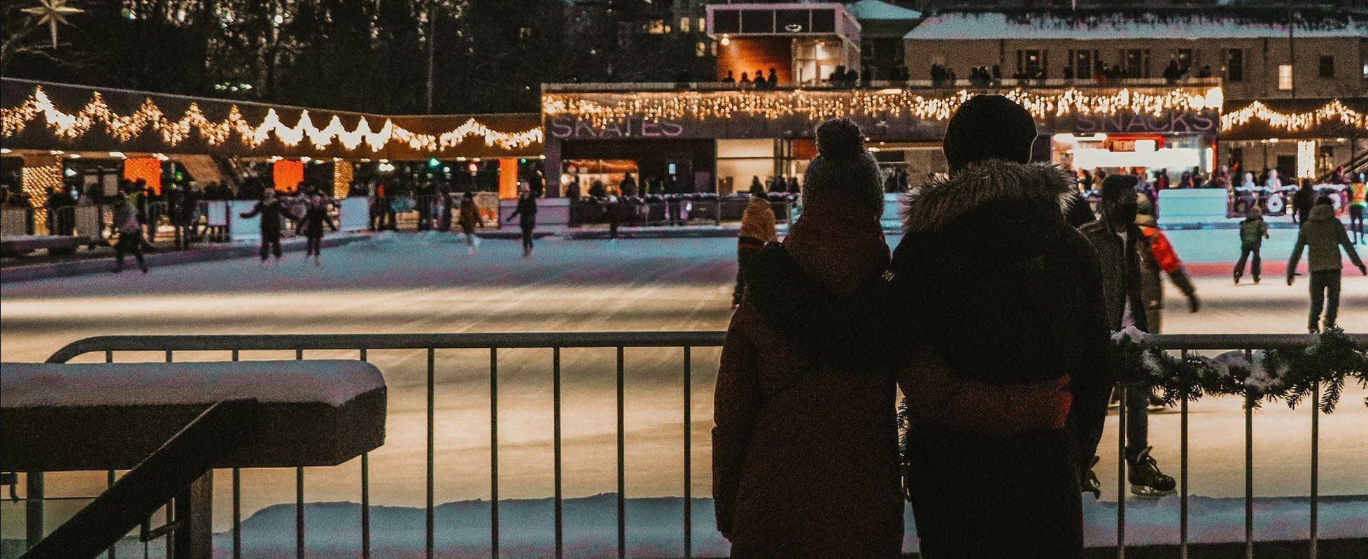 couple watching ice skaters during december