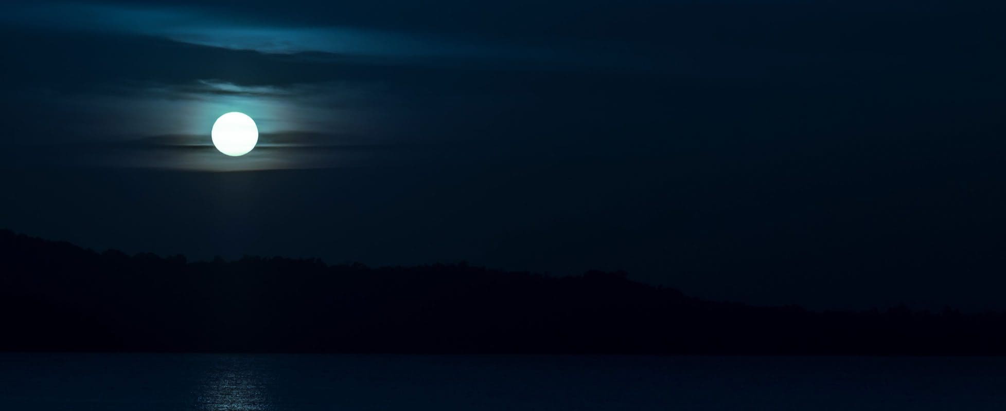 full moon beaming over lake