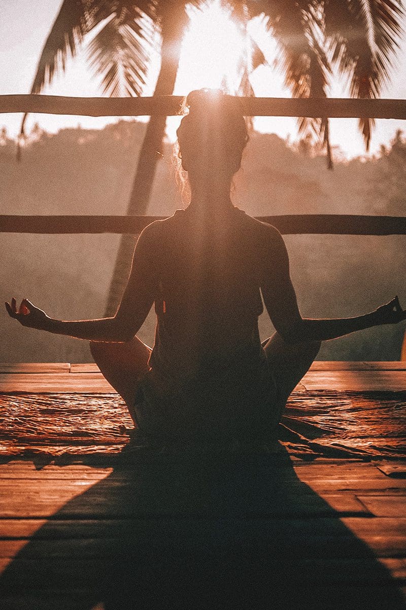 woman meditating during sunrise